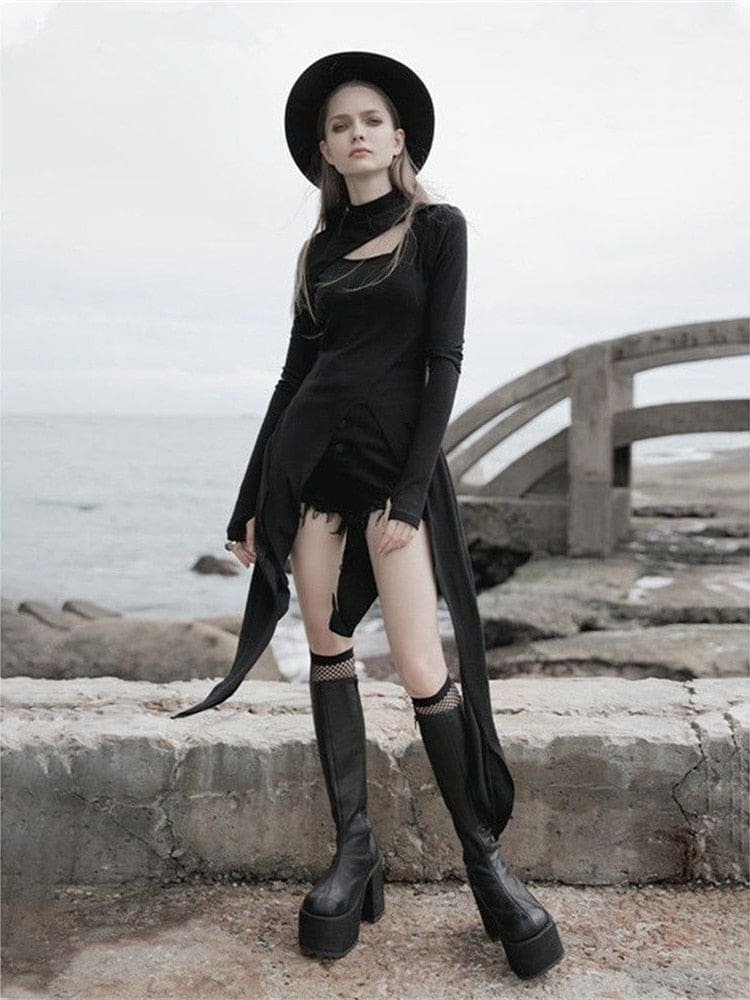 Front coastal view of the black Witching Hour layering dress, with the asymmetric chest cutout and pointed tails visible above tall boots.