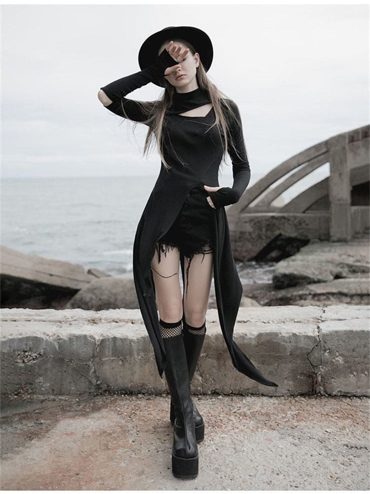 Front view of a black split-front layering dress with hand-covering sleeves and long pointed tails, styled with shorts, knee-high boots and a black hat.