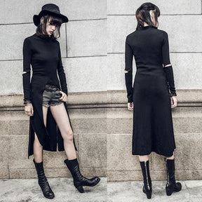 Side-by-side front and back outfit views of the black Witchy high-low dress against a stone wall. Separate shorts show beneath the high curved front opening, while the long back and elbow cutouts remain visible.