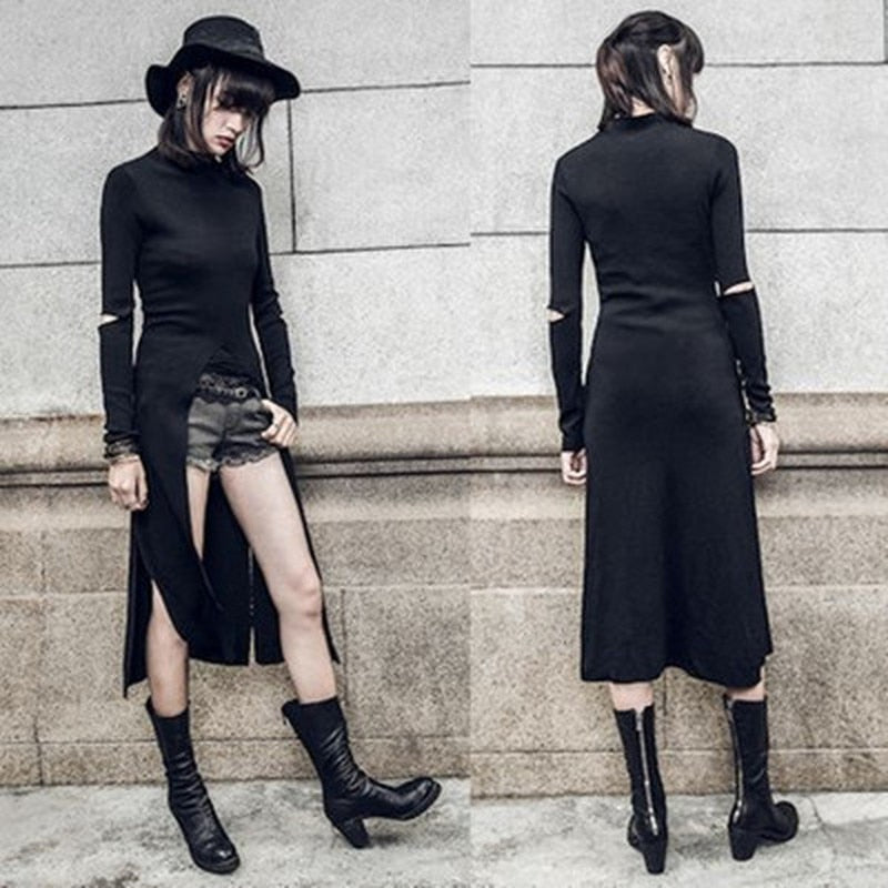 Side-by-side front and back outfit views of the black Witchy high-low dress against a stone wall. Separate shorts show beneath the high curved front opening, while the long back and elbow cutouts remain visible.
