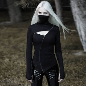 Witchy Ninja top shown standing outdoors with the collar raised and arms lowered, revealing the long sleeve cuffs and uneven pointed hem.