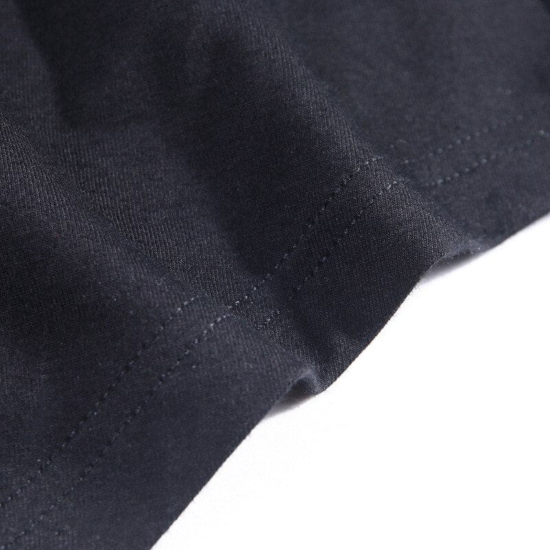 Close-up of the black top’s folded hem and parallel stitching.