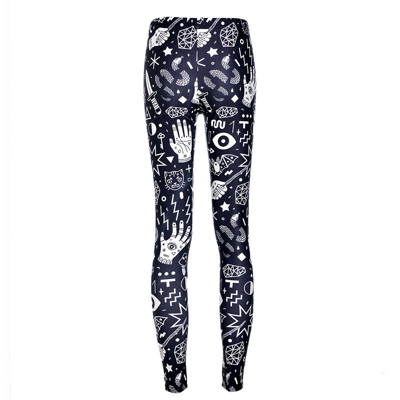 Rear view of black witchy leggings with the white celestial and palmistry print continuing from the waist to the narrow ankles.