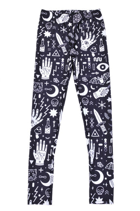 Black and white occult-print leggings laid flat, showing the waistband and full length of both patterned legs.