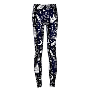 Front product view of slim black leggings with densely arranged white hands, eyes, crescent moons and geometric symbols running down both legs.
