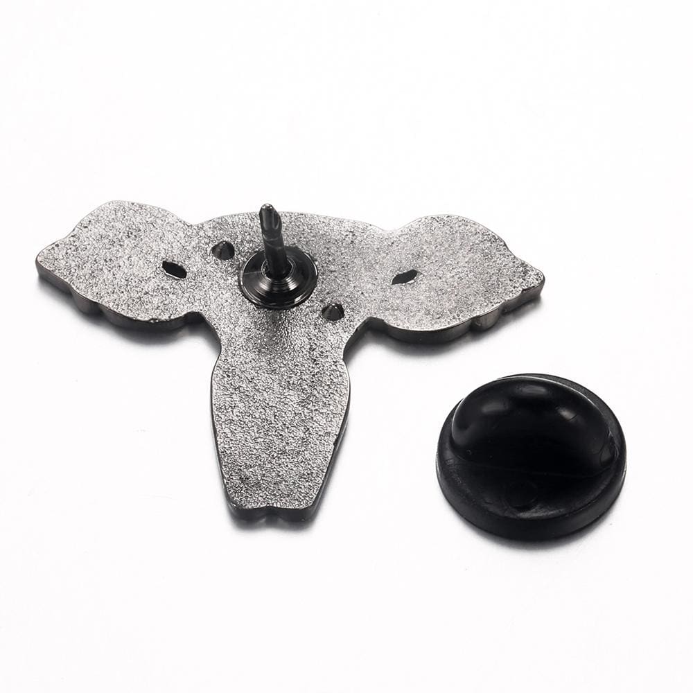 Reverse of the Woman Up uterus pin on white, showing its textured silver-tone back, single post and removable black rubber clutch.