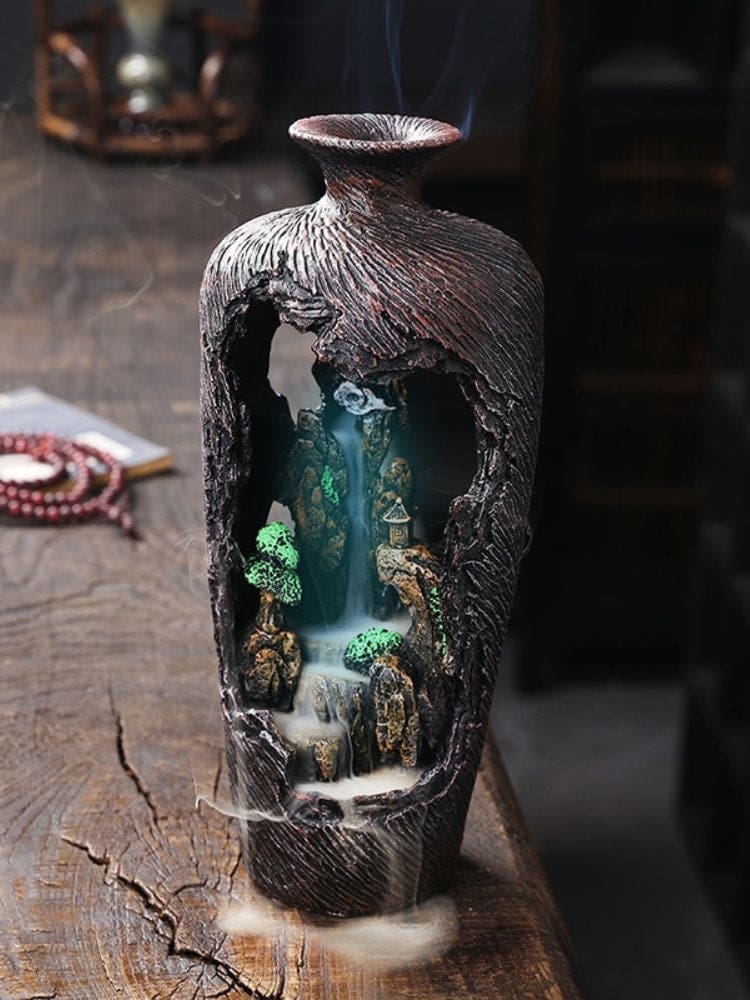 The woodland vase incense burner with a blue-lit interior, showing miniature pavilions and a smoke trail inside the open front.