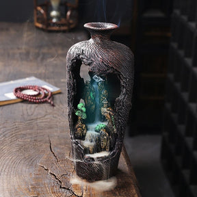 LED version of the brown vase burner with blue illumination beneath its miniature landscape and rising carved exterior.