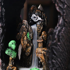 Detail of the incense cone above the rocky interior scene, with tiny trees, pavilions and a pale cloud-like ledge.
