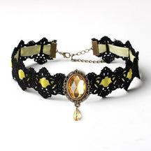 Black lace choker with an ornate oval centerpiece and hanging teardrop in the Yellow ribbon and jewel option.