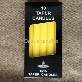Yellow slender ritual candles displayed beside their box, with the candle tops and wicks visible.