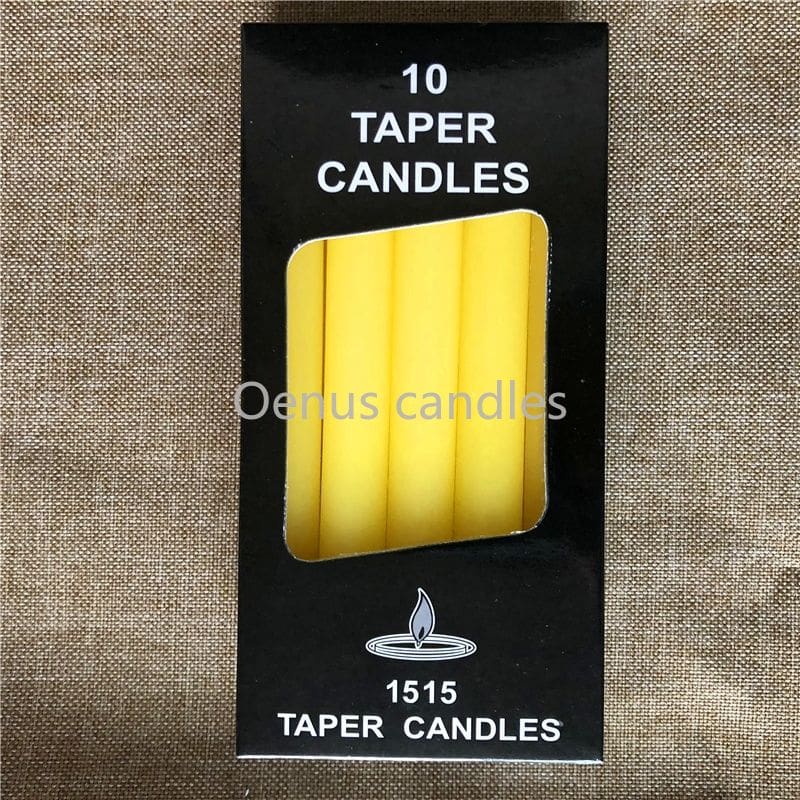 Yellow slender ritual candles displayed beside their box, with the candle tops and wicks visible.