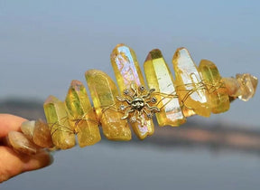 Yellow crystal tiara with a gold-tone sun face centred beneath a row of warm yellow points.